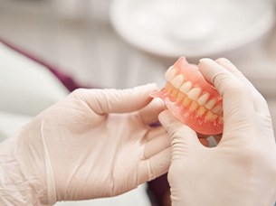 Dentist holding pair of dentures