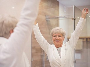 Woman looking in her bathroom mirror after checking her mouth for changes